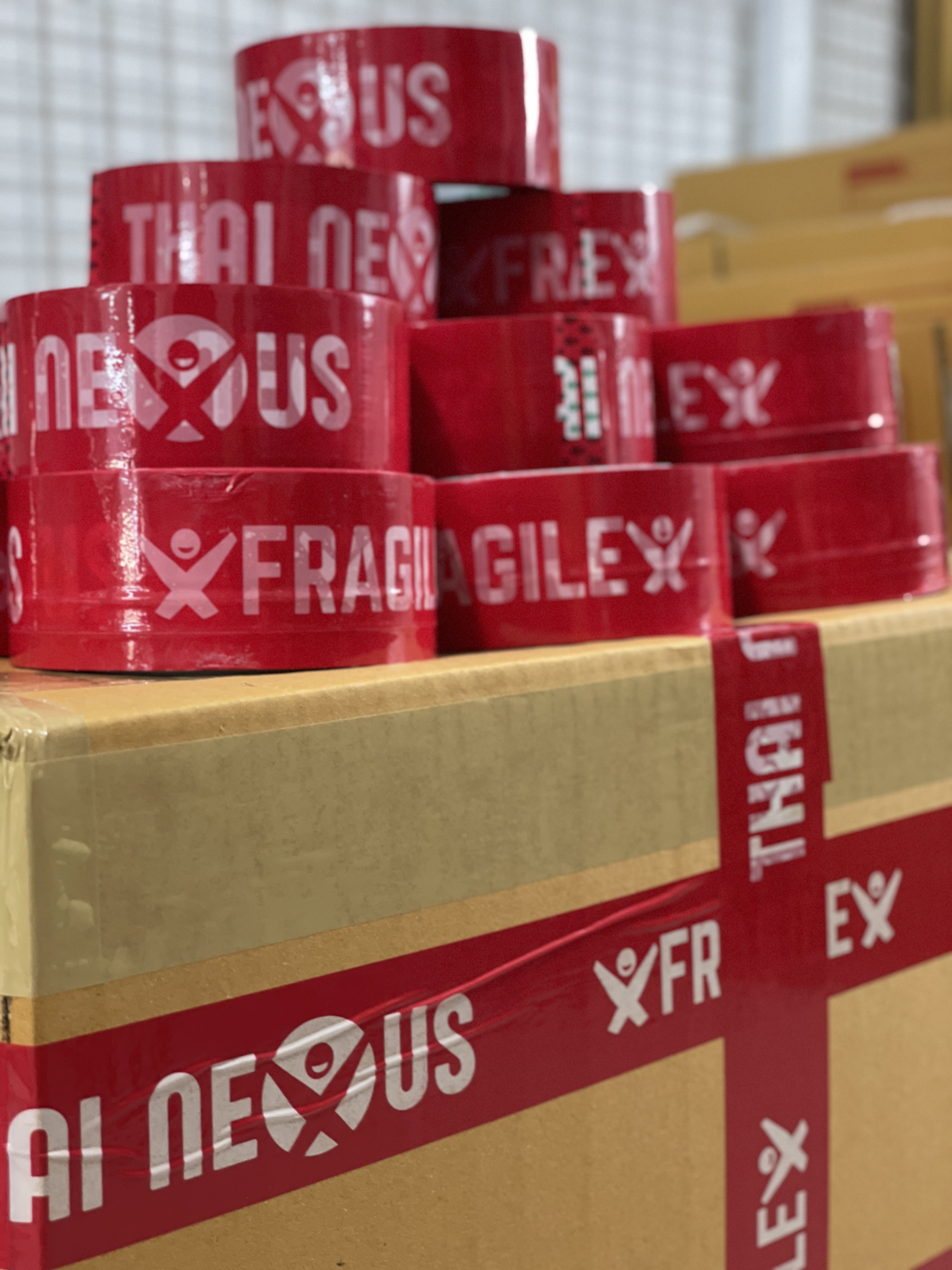 Thai Nexus branded packing tape rolls at the export bench
