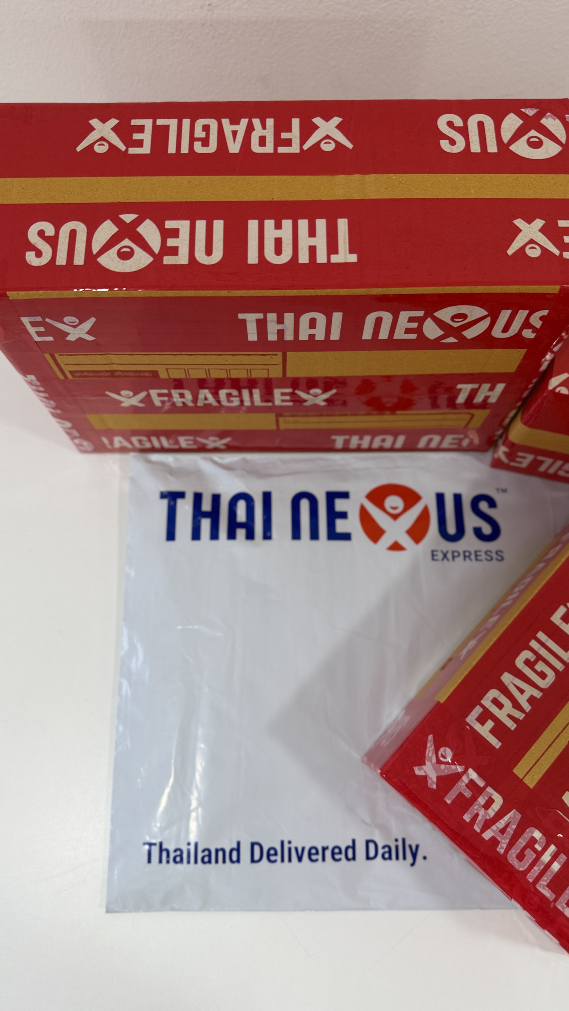 Thai Nexus fragile sticker on a poly mailer and export box